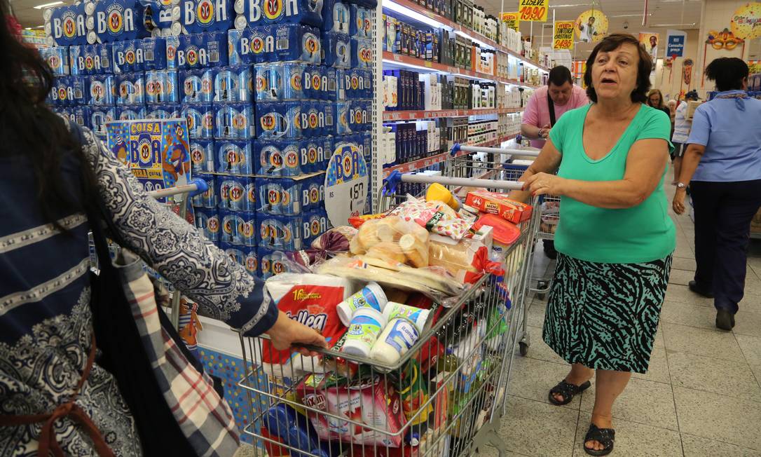 
A aposentada Sueli Pereira faz compras em supermercado no Centro do Rio: ainda que a inflação tenha caído pela metade em 2017, muito produtos ainda estão mais caros que no final de 2014 como o arroz, feijão, leite, banana e açúcar
Foto:
/
Custódio Coimbra
