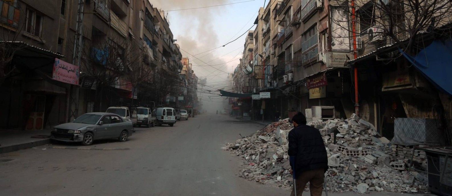 Sírio caminha em uma rua de Douma, cidade em Ghouta Oriental, sob o cerco do regime: “A noção de guerra justa supõe que haja guerras injustas, mas quem decide o que é excessivo?”, observa Rony Brauman Foto: HAMZA AL-AJWEH / AFP