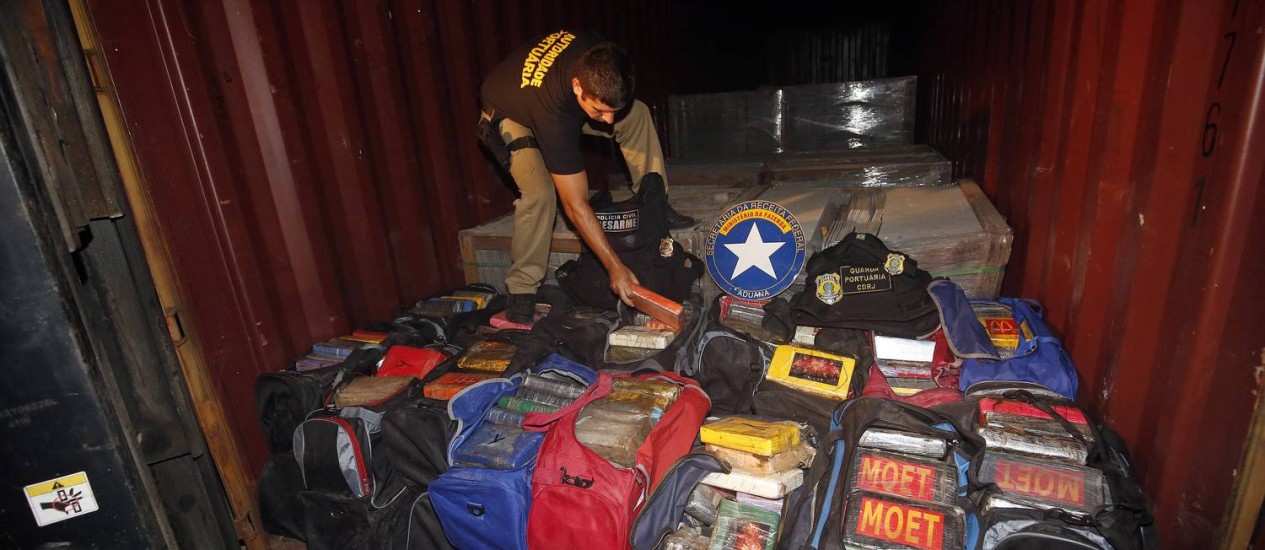 Agente organiza parte do material apreendido em um dos contêineres onde a policia encontrou a cocaína Foto: MARCOS DE PAULA / Agência O Globo
