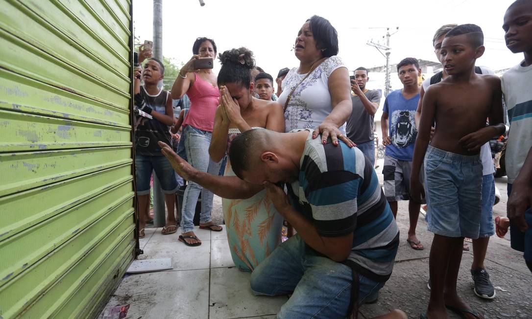 Casal reza em frente a quiosque na Vila Kennedy antes dele ser destruído pelo prefeitura Foto: Marcio Alves / Agência O Globo