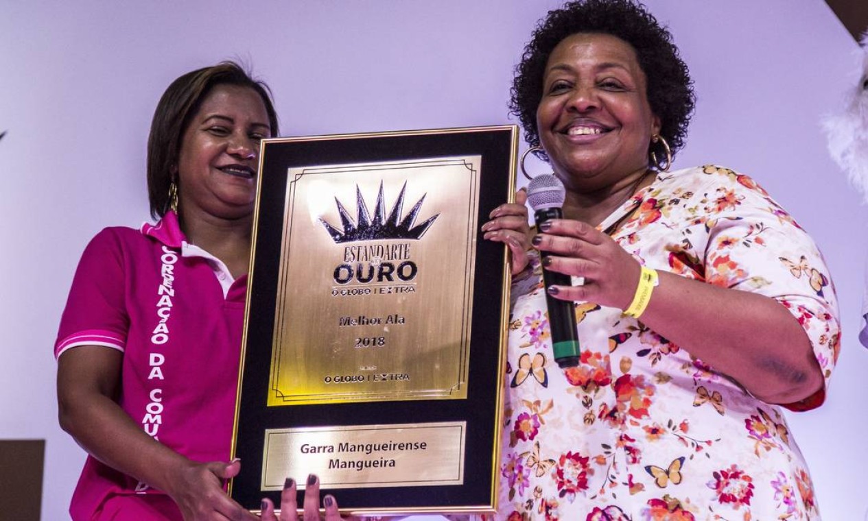Integrante da Mangueira recebe o prêmio pela melhor ala. Escola veio com um tom crítico Foto: Hermes de Paula / Agência O Globo