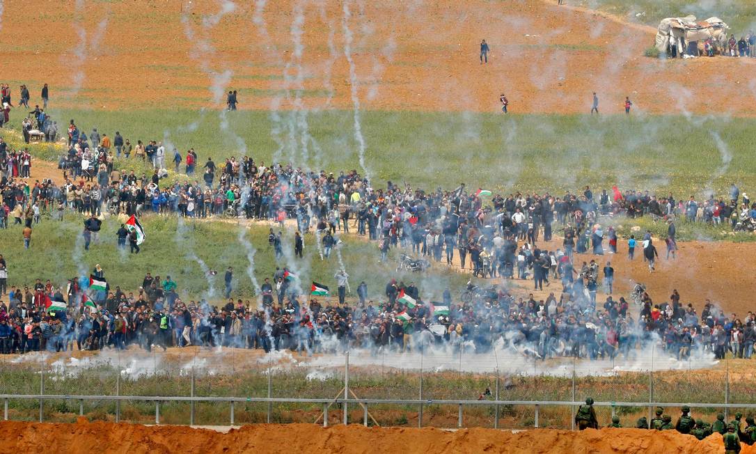 Granadas de gás caem sobre os palestinos durante protesto pelo Dia da Terra, na divisa com a Faixa de Gaza Foto: JACK GUEZ / AFP
