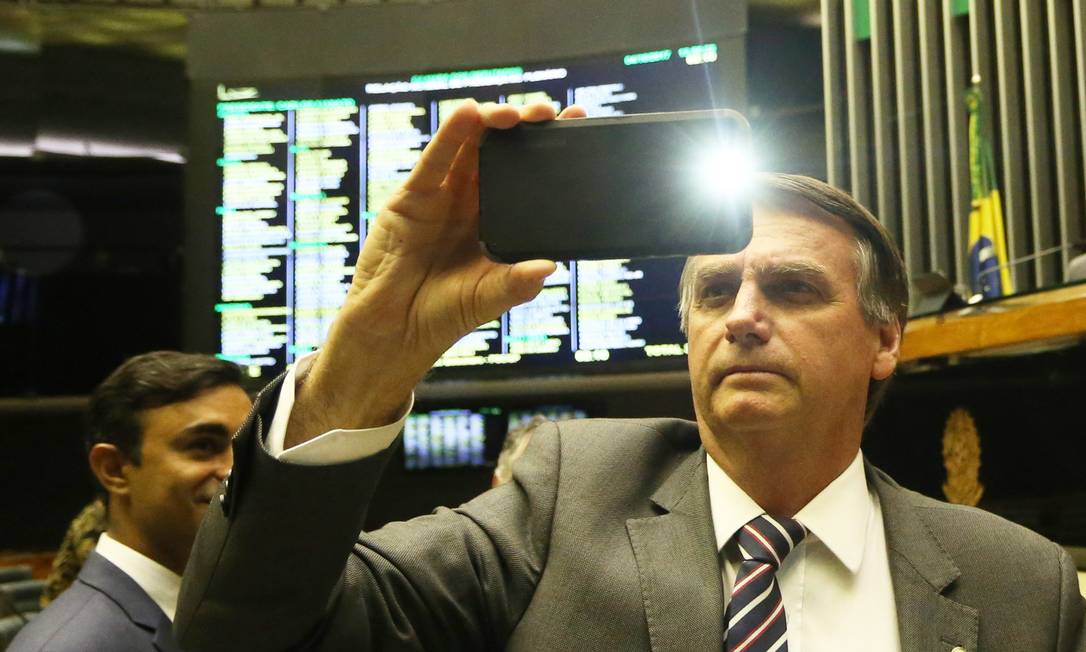 Bolsonaro filma sessão no plenário com celular Foto: Ailton de Freitas / Agência O Globo