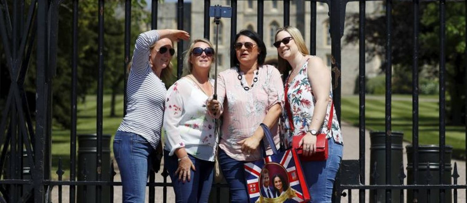
Selfie. Lembranças do casamento em pose no portão do Castelo de Windsor
Foto: PHIL NOBLE / REUTERS