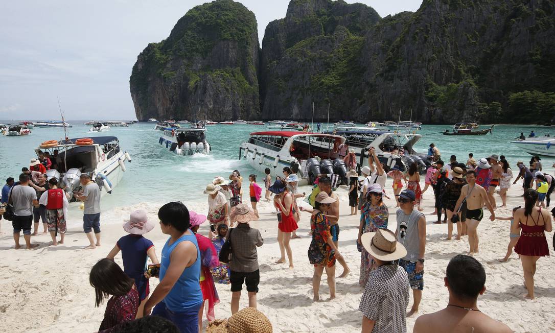 Turistas lotam a praia na Baía Maya, em Koh Phi Phi Leh, a praia mais famosa da Tailândia, que ficará fechada por quatro meses para a recuperação de seu ecossistema Foto: Sakchai Lalit / AP