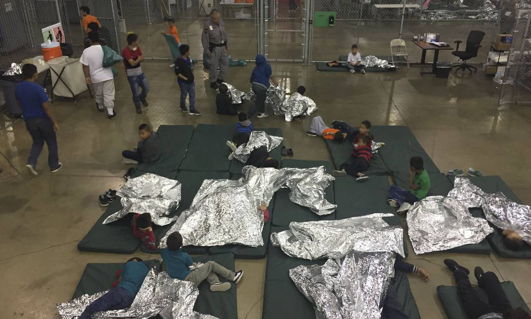 Crainças migrantes que tentaram atravessar a fronteira para os EUA de forma irregualar dormem em centro de processamento no Texas Foto: HANDOUT / AFP