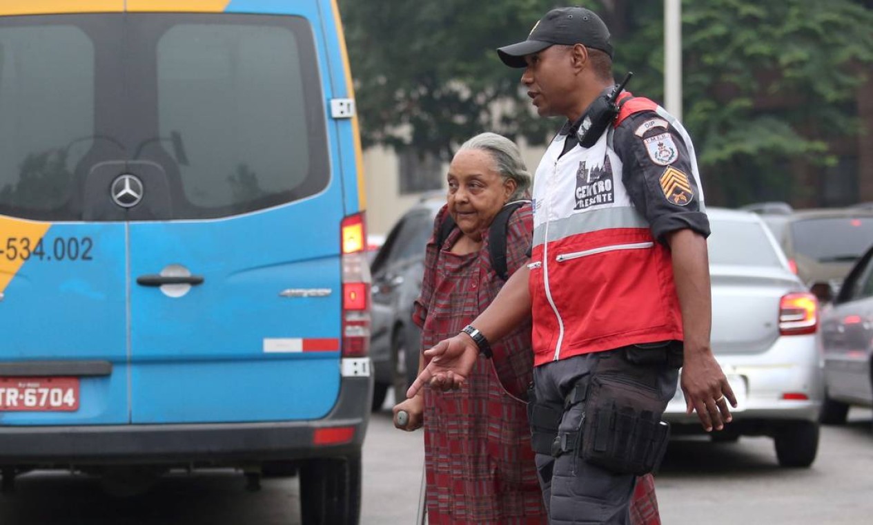 Policial do Centro Presente ajuda idosa a atravessar a rua na Avenida Presidente Vargas Foto: Fabiano Rocha / Agência O Globo