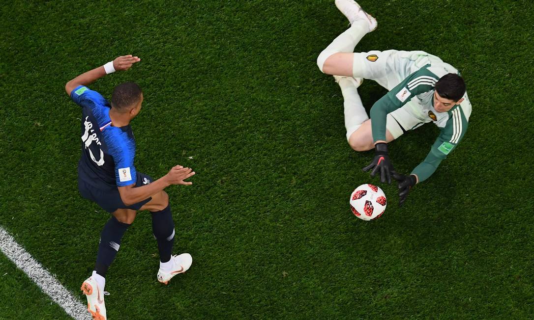 O francês Mbappé para no goleiro belga Courtois durante a semifinal Foto: JEWEL SAMAD / AFP