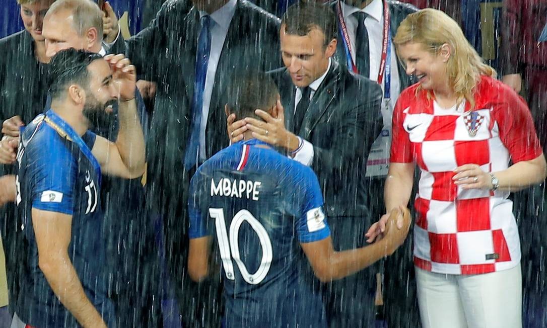 O presidente francÃªs, Emmanuel Macron, e a presidente croata, Kolinda Grabar-Kitarovic, cumprimentam os jogadores MAXIM SHEMETOV / REUTERS
