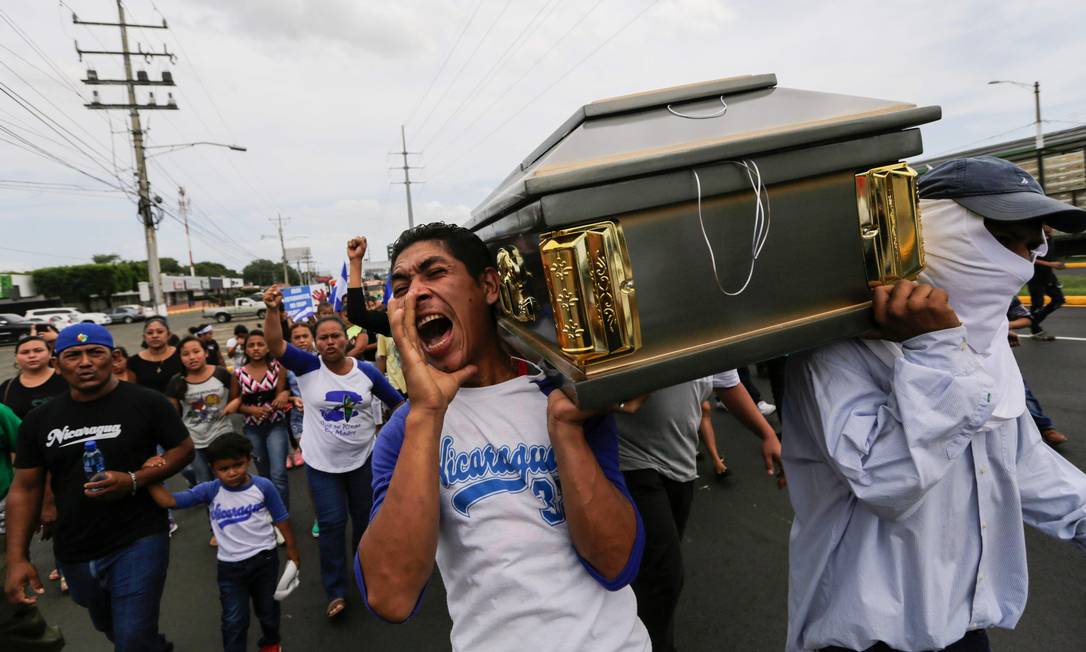 Amigos e parentes carregam o corpo de Gerald Velazquez, estudante da Universidade Nacional Autônoma da Nicarágua morto no domingo durante um cerco de paramilitares a uma igreja próxima ao campus Foto: INTI OCON / AFP