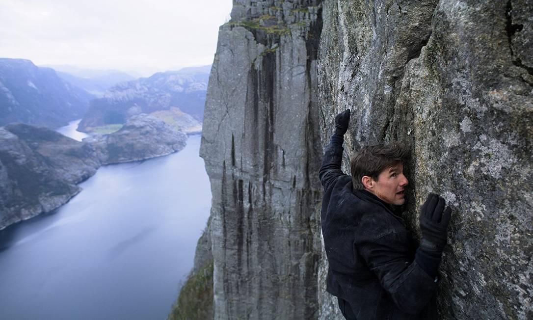 Tom Cruise se agarra ao paredão rochoso conhecido como Pedra do Púlpito, na Noruega, numa cena de "Missão Impossível - Efeito Fallout" Foto: Divulgação