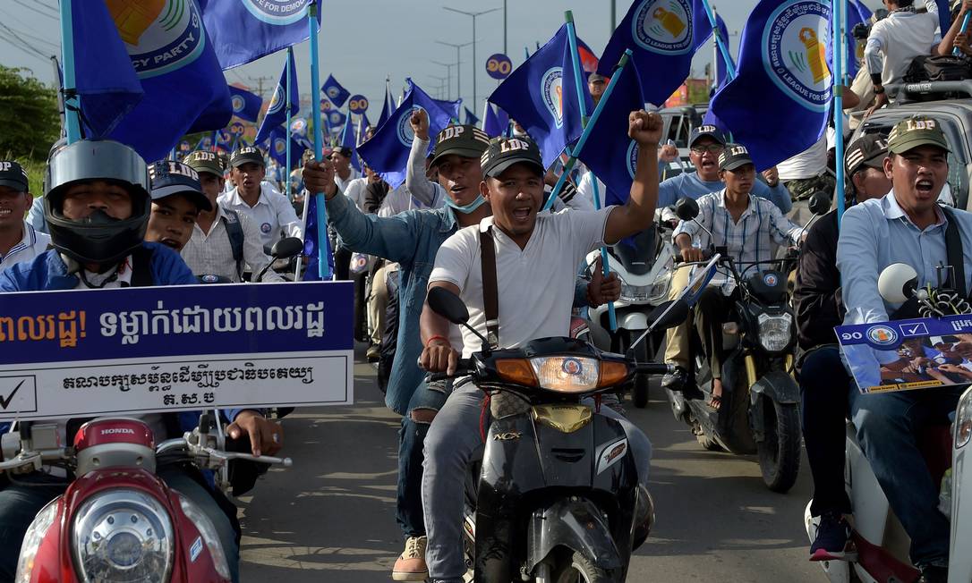 Eleitores manifestam apoio a primeiro-ministro cambojano, Hun Sen, que está há 33 anos no poder: eleições desse domingo são acusadas de fraude pela oposição Foto: TANG CHHIN SOTHY / AFP