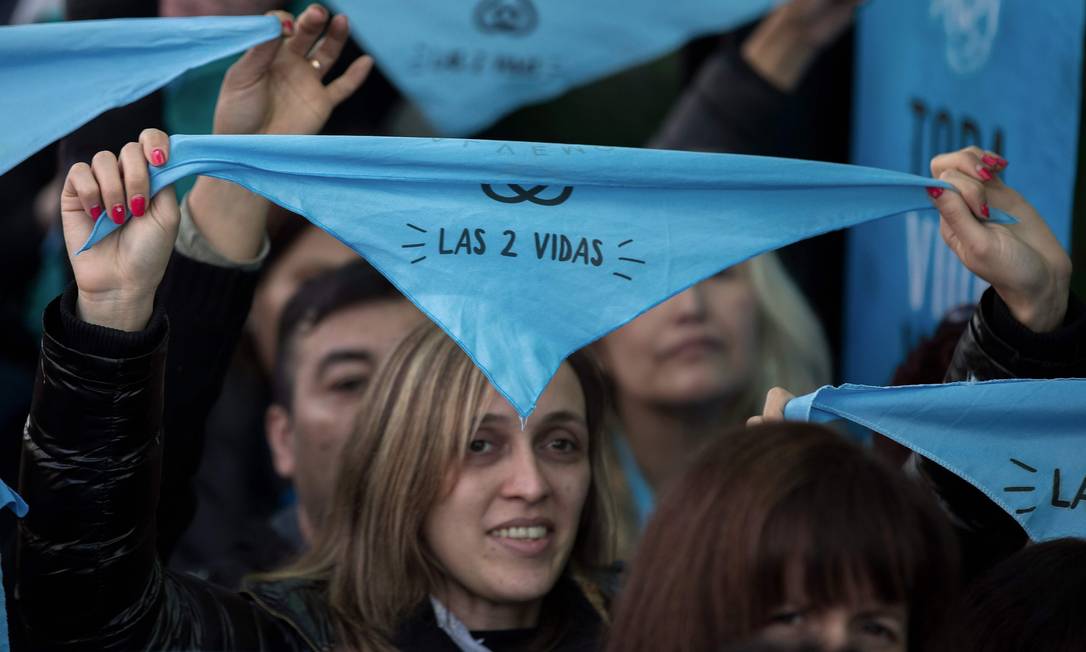 
Pessoas contrárias ao aborto seguram lenços azuis com o slogan “as duas vidas” das campanha que pede a rejeição do projeto que legaliza a prática pelo Senado argentino no último sábado em Buenos Aires
Foto:
/
AFP/Alejandro Pagni
