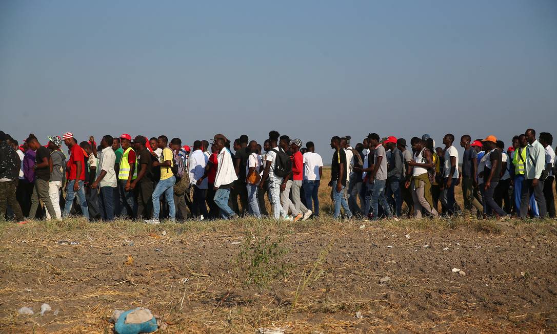 Imigrantes africanos em marcha de protesto contras baixas condições de trabalho, nos arredores de Foggia Foto: ALESSANDRO BIANCHI / REUTERS