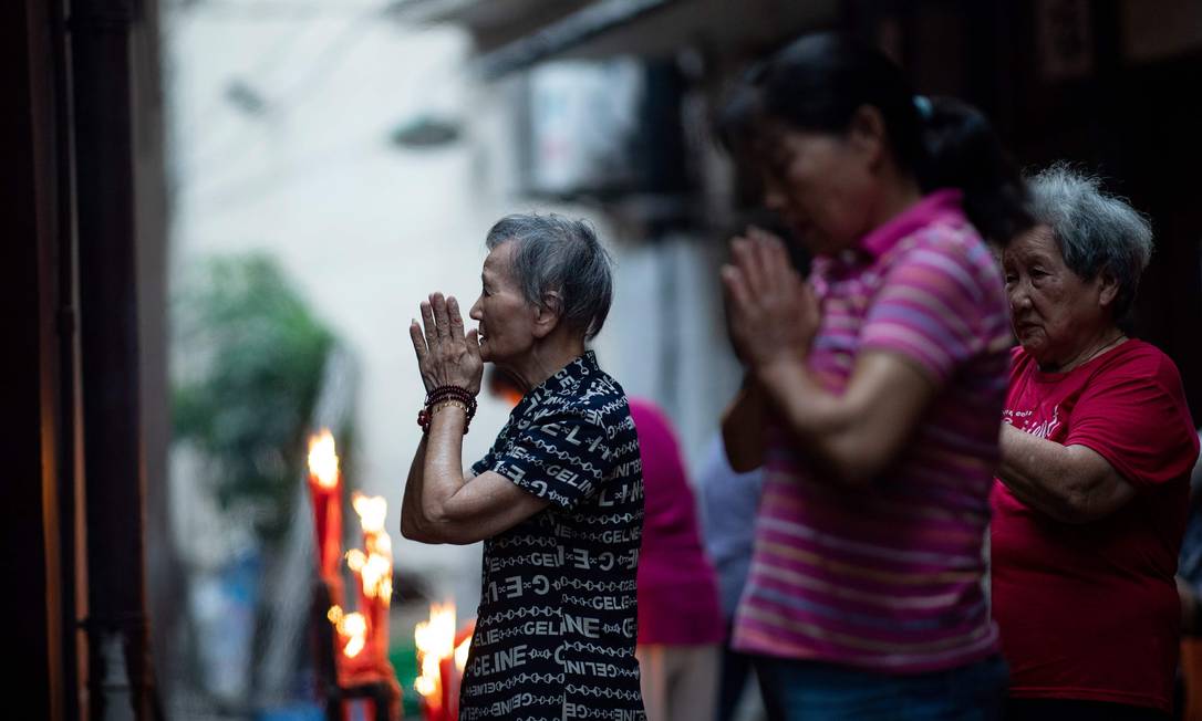 Cidadãos chineses rezam de frente ao templo de Hong Miao, em agosto Foto: JOHANNES EISELE / AFP