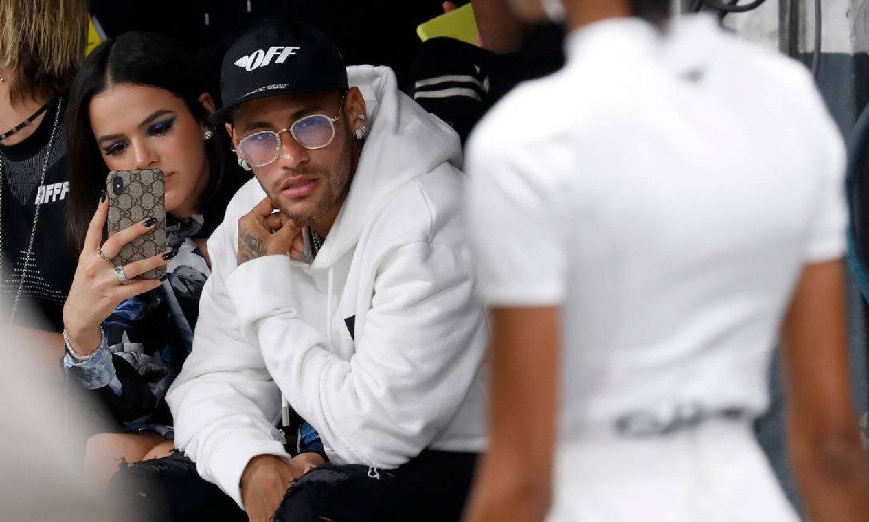 Neymar e Bruna Marquezine foram o assunto dessa quinta-feira na semana de moda de Paris. Foi a primeira vez que eles assistiram a um desfile juntos. Aqui, mostramos a reação do casal durante a apresentação da Off-White, um outro ângulo da dupla na fila A. Bruna, por exemplo, não largou o celular, equipado com uma capinha da Gucci Foto: FRANCOIS GUILLOT / AFP