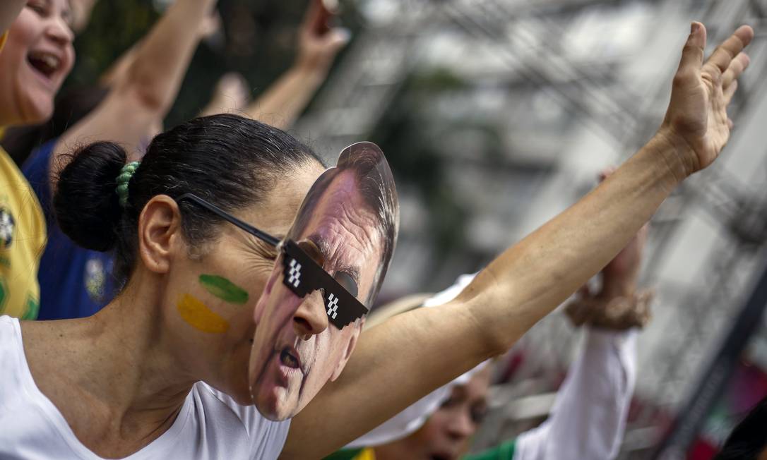 Apoiadora usa máscara de Jair Bolsonaro durante ato em São Paulo Foto: MIGUEL SCHINCARIOL / AFP