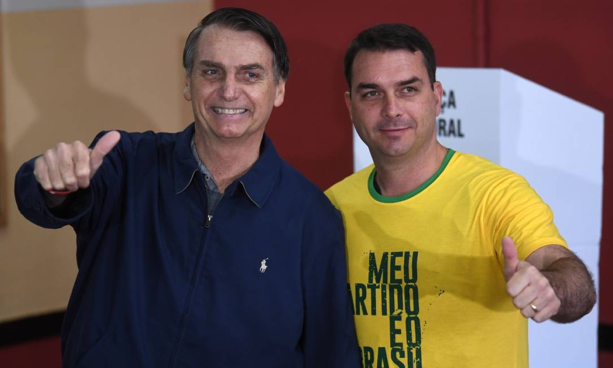 O capitão reformado, que, segundo o Datafolha, tem 40% dos votos válidos, posou para fotos ao lado do filho, o candidato ao Senado Flávio Bolsonaro Foto: MAURO PIMENTEL / AFP