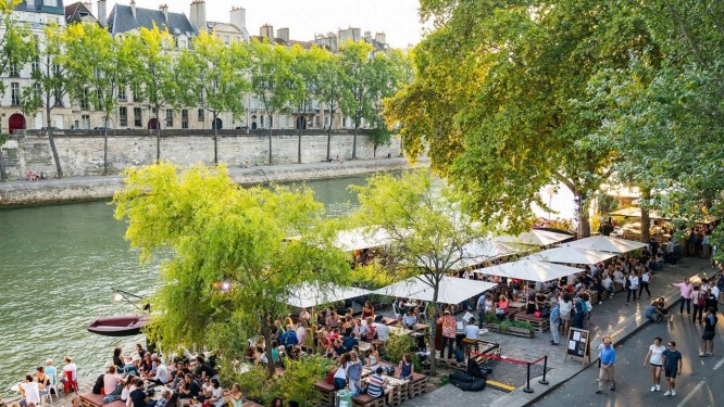 Mesas e cadeiras se espalham ao longo do Rio Sena, em Paris, perto da embarcação Peniche Marcounet Foto: Jo Han Pai / The New York Times