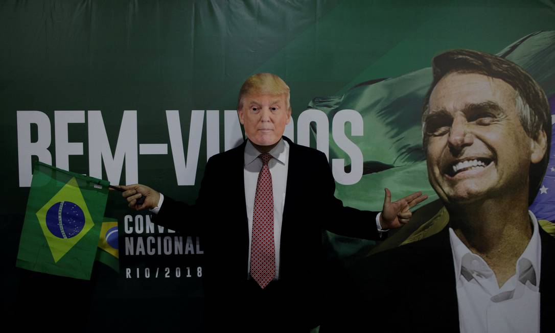 Um apoiador de Bolsonaro usa máscara do presidente americano Donald Trump antes da convenção nacional do partido PSL Foto: Ricardo Moraes / REUTERS