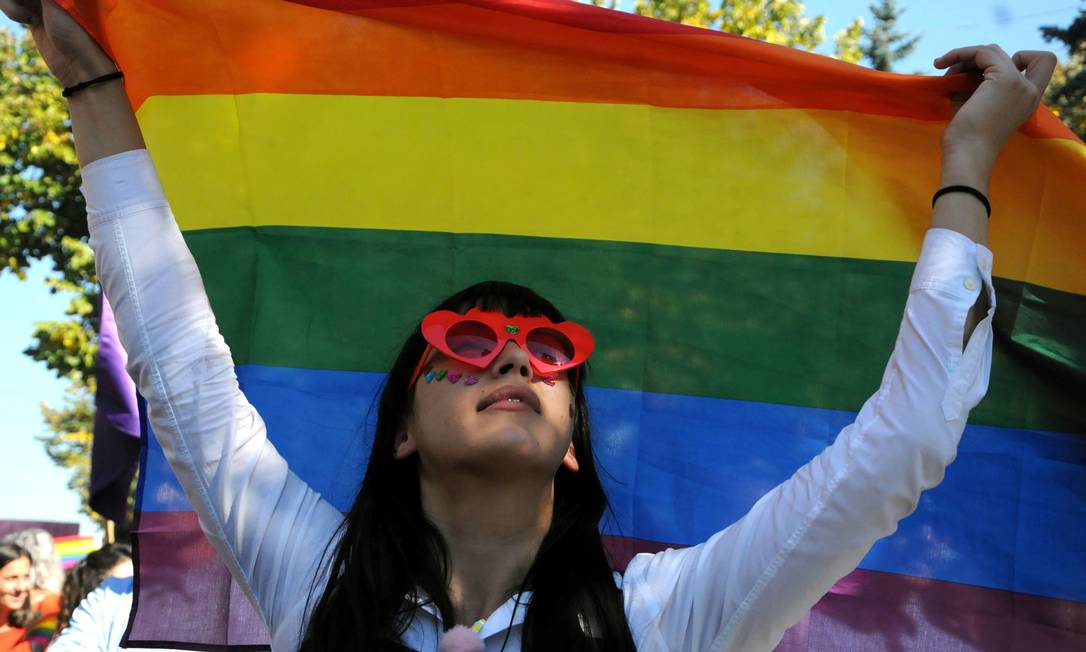 Mulher segura a bandeira que representa lésbicas, gays, bissexuais e transgêneros Foto: LAURA HASANI / REUTERS