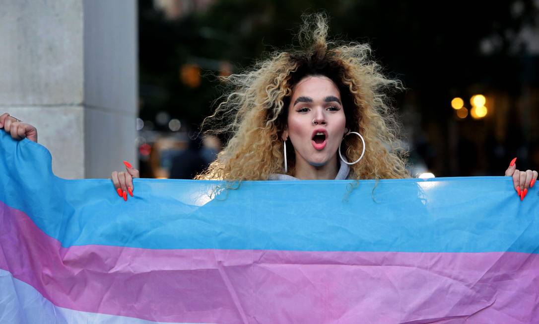 Mulher trans segura a bandeira da comunidade transexual, em Nova York Foto: Yana Paskova / AFP