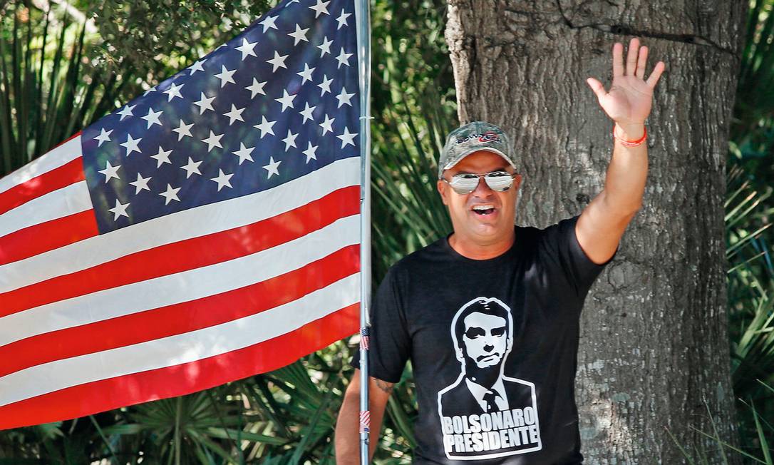 Eleitor brasileiro faz propaganda para Jair Bolsonaro em zona eleitoral de Orlando, na Flórida. O presidente eleito recebeu 81,7% dos votos nos Estados Unidos Foto: Gregg Newton / AFP