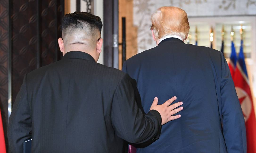 Líder da Coreia do Norte, Kim Jong-un caminha ao lado do presidente americano Donald Trump, durante cúpula em Cigapura Foto: SAUL LOEB 12-06-2018 / AFP