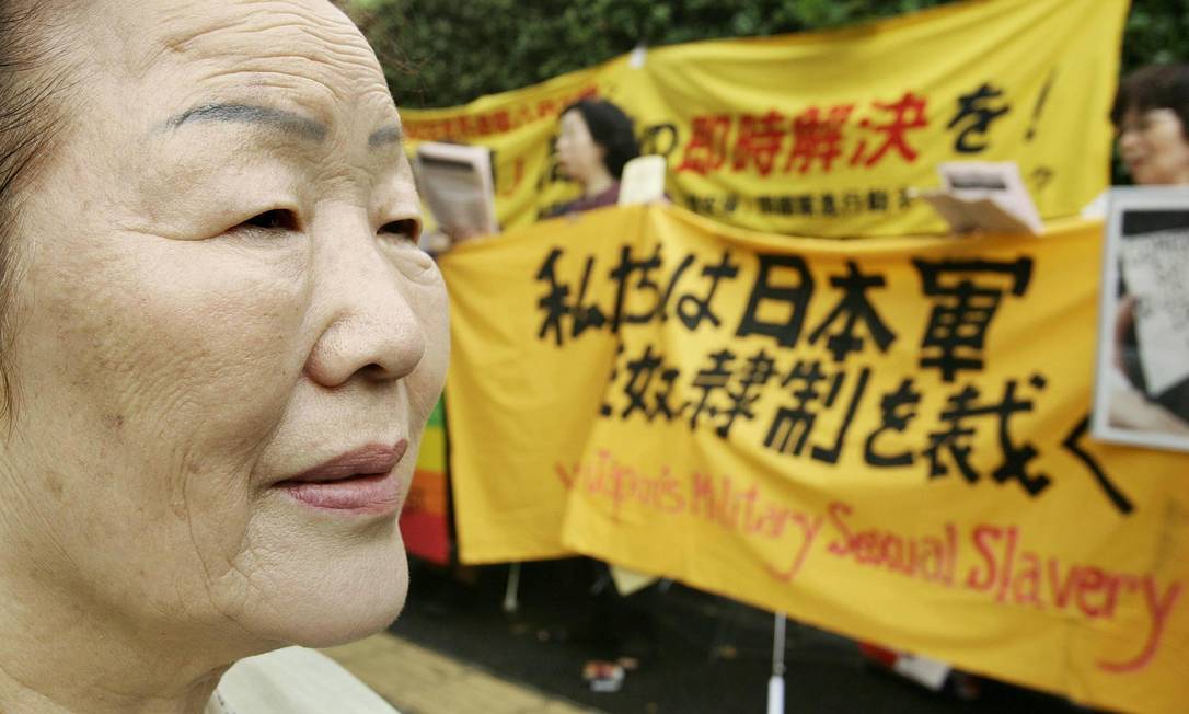 Ex-'mulher de conforto' da Coreia do Sul observa manifestantes que apoiavam a causa das ex-escravas sexuais de soldados japoneses durante protesto de agosto de 2005 Foto: AFP