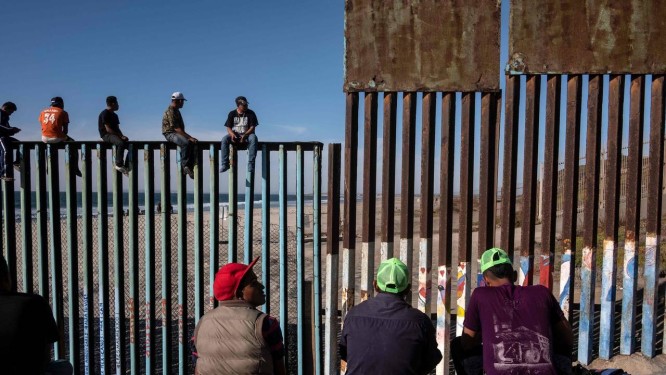 Grupo de imigrantes centro-americanos aguardam na fronteira entre EUA e MÃ©xico em Playas de Tijuana Foto: GUILLERMO ARIAS / AFP