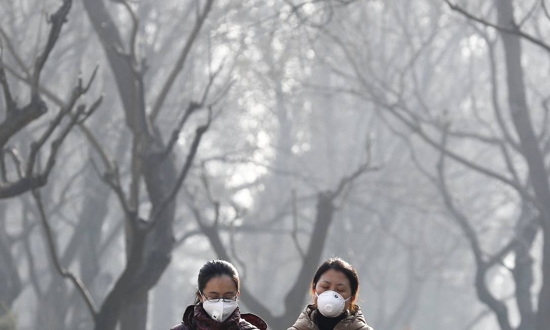 Chinesas usam máscara em parque de Pequim: poluição atmosférica é problema frequente no país Foto: Andy Wong / AP/19-12-2016