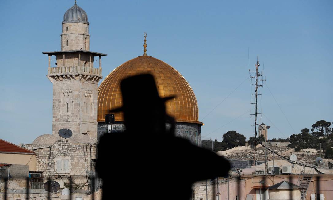 Judeu ultraortodoxo com o Domo da Rocha da Mesquita de al-Aqsa ao fundo, em Jerusalém Foto: AHMAD GHARABLI / AFP