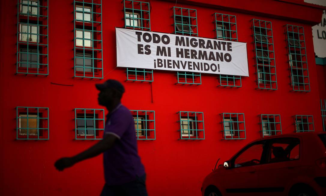 Haitiano passa por faixa de saudação a imigrantes em igreja no Chile, que recentemente adotou uma política migratória mais restritiva Foto: Ivan Alvarado / REUTERS