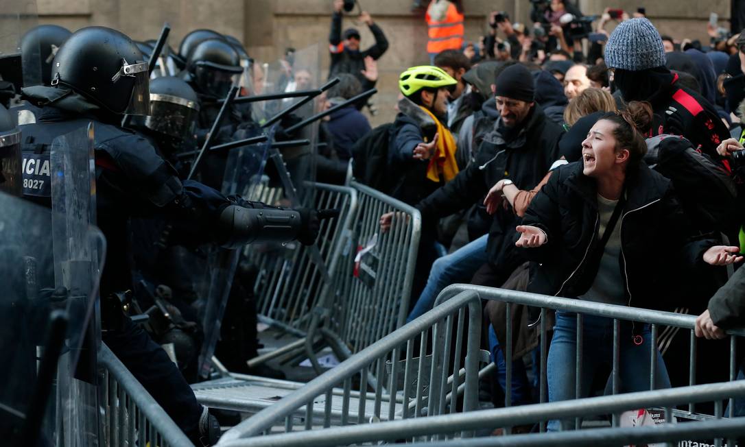 Membros da polícia regional da Catalunha encaram manifestantes durante protesto pró-independência Foto: PAU BARRENA / AFP