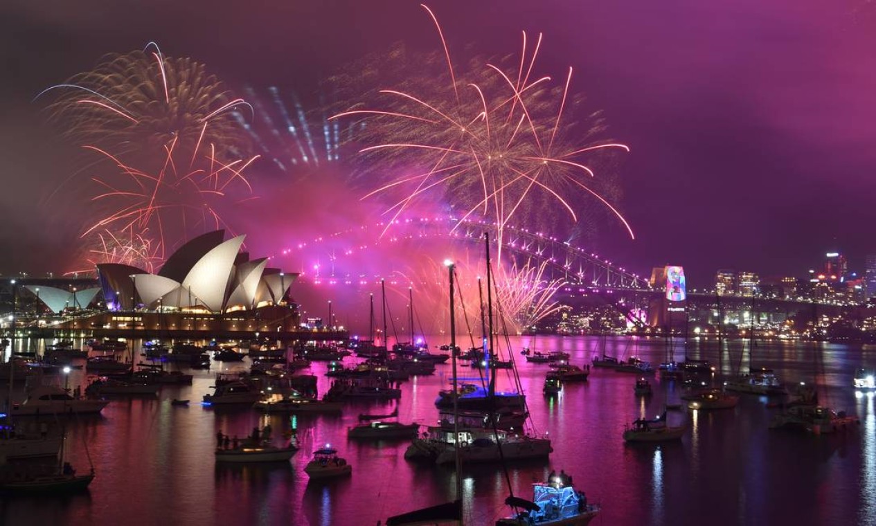 A Harbour Bridge e a Opera House de Sydney durante a tradicional primeira queima de fogos às 21h Foto: PETER PARKS / AFP