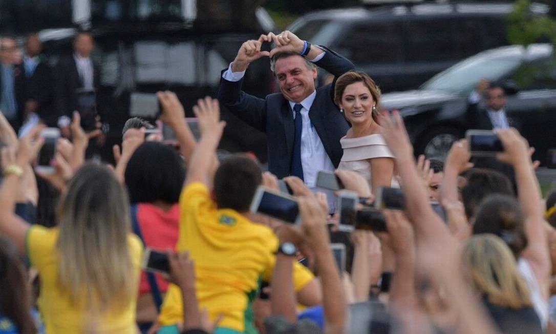 Jair Bolsonaro faz símbolo de coração com as mãos na direção de eleitores ao chegar no Congresso Nacional CARL DE SOUZA / AFP
