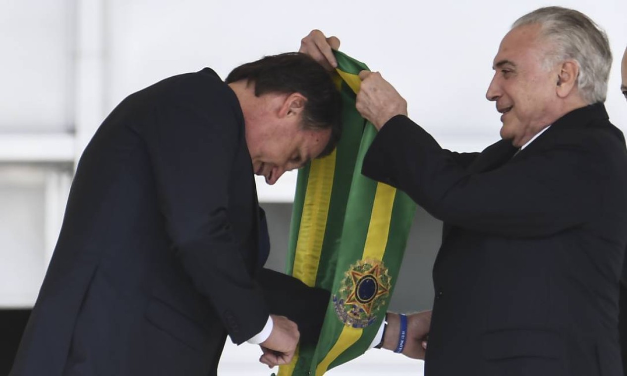 Presidente Jair Bolsonaro recebe a faixa presidencial do ex-presidente Michel Temer Foto: EVARISTO SA / AFP