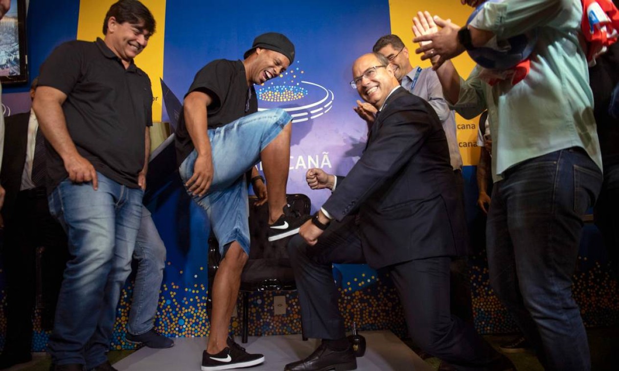 Durante homenagem a Ronaldinho Gaúcho, no Maracanã, no dia 8 de janeiro, quando o craque colocou seus pés na calçada da fama do estádio, lá estava Witzel de novo; na foto, ele finge engraxar as chuteiras do ex-jogador, comemoração comum no mundo do futebol Foto: MAURO PIMENTEL / AFP