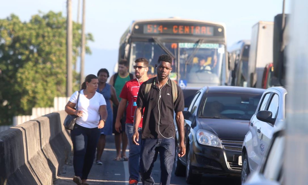 Com o trânsito parado, os passageiros abandonam os ônibus para fugir do engarrafamento Foto: Fabiano Rocha / Agência O Globo