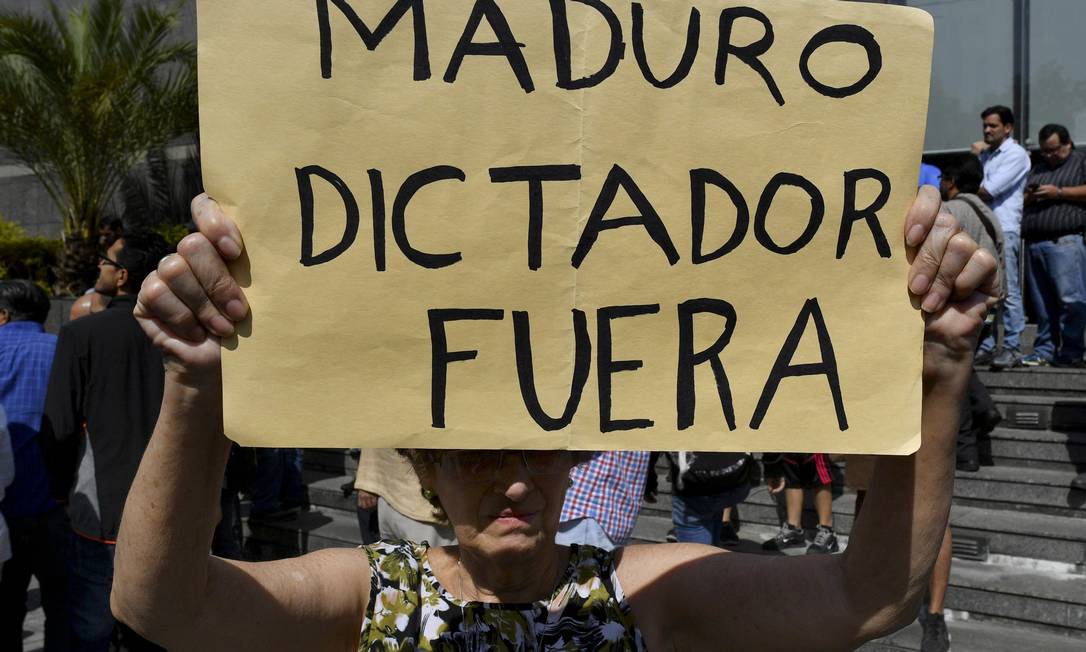 Manifestante carrega cartaz contra o presidente venezuelano, Nicolás Maduro, durante protesto em Caracas Foto: YURI CORTEZ / AFP