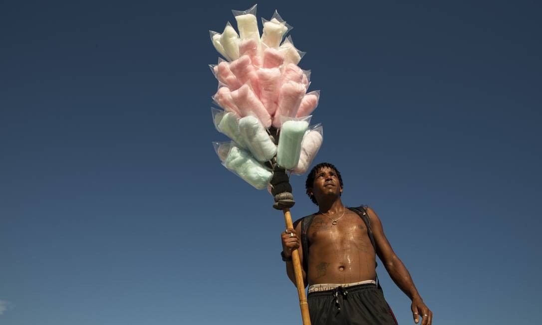 Cristiano Mattos dispensa a camisa para vender seu algodão doce na Praia de Copacabana Ana Branco / Agência O Globo