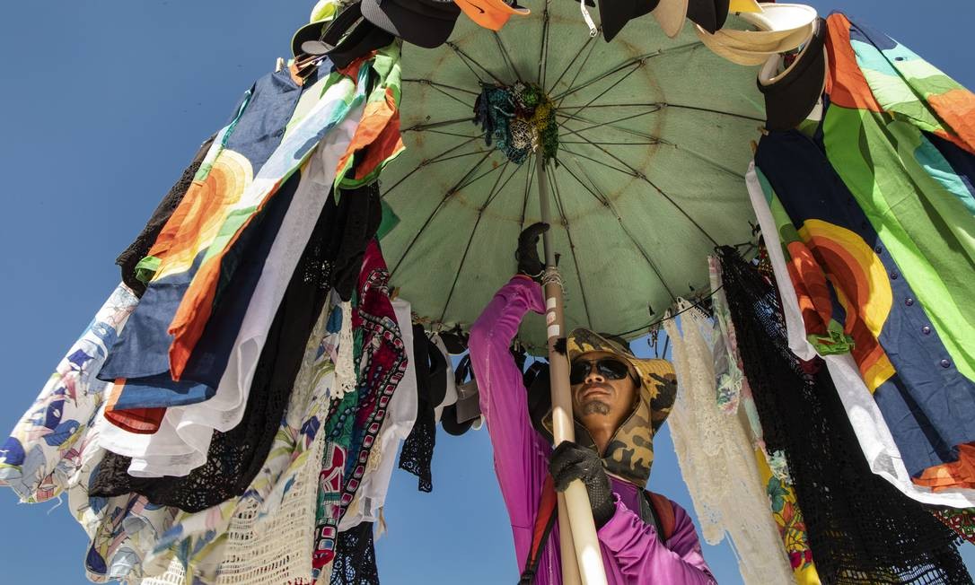 Rodeado de pano, o recifense Cícero José da Silva, de 34 anos, vende seus produtos na praia Ana Branco / Agência O Globo