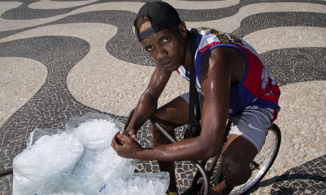 Wagner Gonçalves Lima, de 33 anos, precisa correr para conseguir entregar o gelo ao cliente na Praia do Leme antes que ele derreta Ana Branco / Agência O Globo