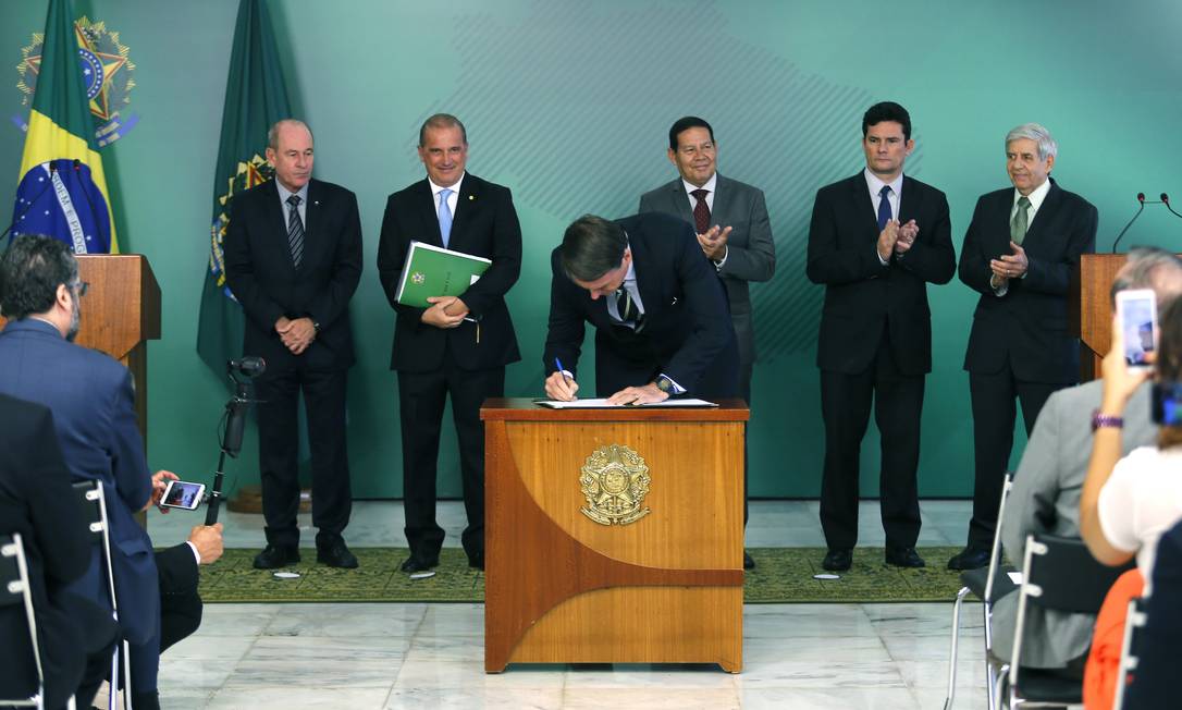 O presidente Jair Bolsonaro ao assinar o decreto de flexibilização da posse de armas
Foto: Jorge William / Agência O Globo