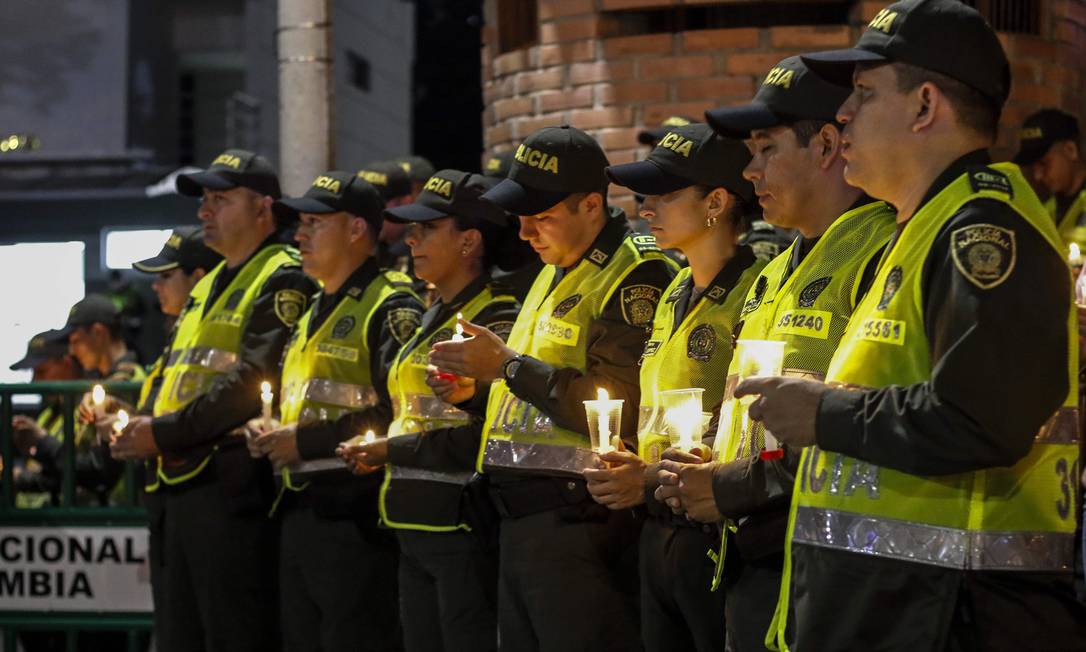 Membros da Polícia Nacional seguram velas em homenagem a colegas mortos em ataque Foto: SCHNEYDER MENDOZA / AFP