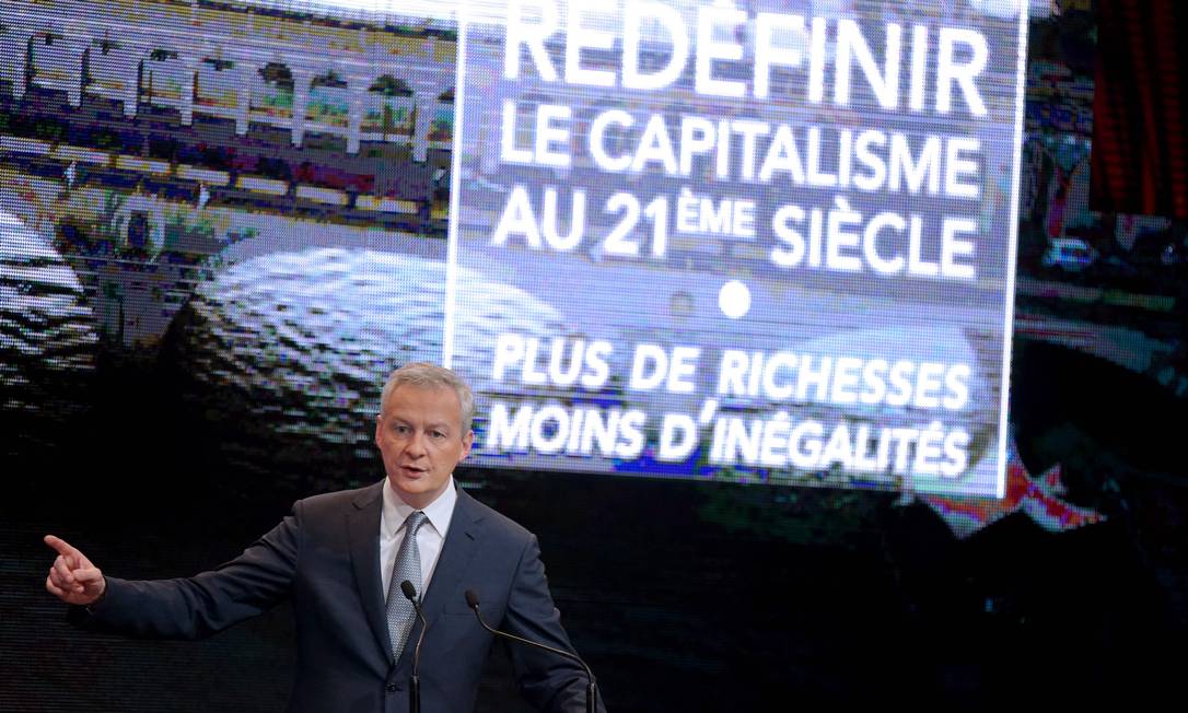 Le Maire discursa: na tela atrás do ministro, está escrito "Redefnir o capitalismo no século XXI. Mais riquezas, menos desigualdades" Foto: ERIC PIERMONT / AFP
