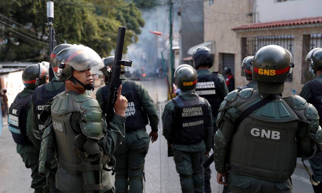 Agentes da Guarda Nacional Bolivariana perto de manifestantes em Caradas no dia 21 de janeiro de 2019 Foto: Carlos Garcia Rawlins / REUTERS