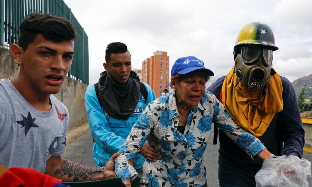Manifestantes após serem atingidos por gás lacrimogêneo em Caracas; governo também convocou marchas de apoio a Maduro Foto: STRINGER / REUTERS