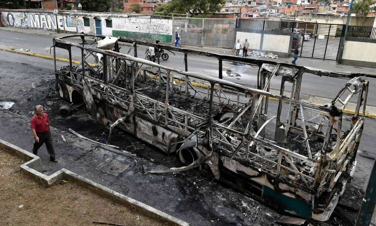 Ônibus queimado em Caracas durante a madrugada, em que houve ao menos 60 focos de protestos na capital venezuelana Foto: LUIS ROBAYO / AFP