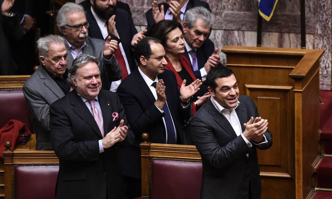 Primeiro-ministro grego, Alexis Tsipras, à direita, celebra aprovação de acordo sobre novo nome da Macedônia Foto: ANGELOS TZORTZINIS / AFP